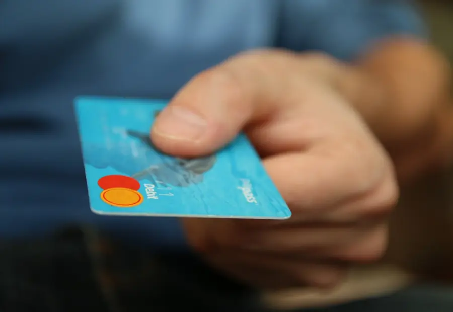 A hand holding out a payment card
