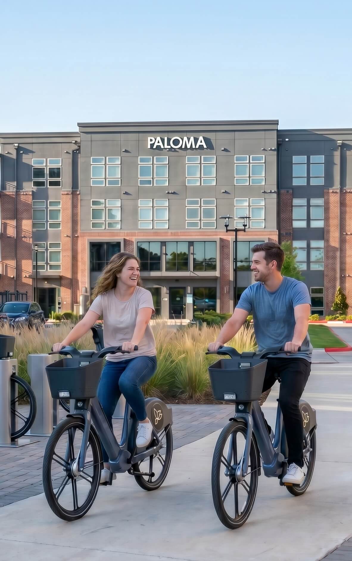Two people using Boomerang electric bikes at property docking station