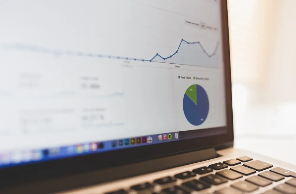 A laptop showing financial charts and a pie chart